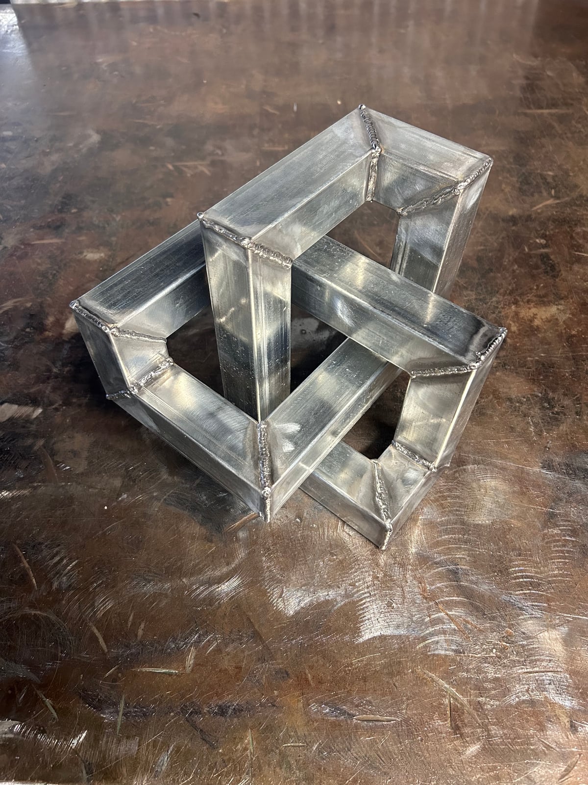 A geometric knotted cube welded from square steel tube